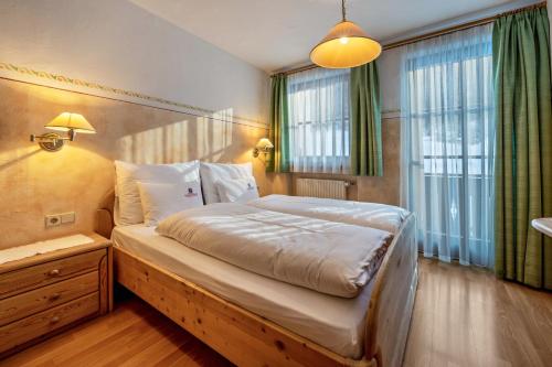1 dormitorio con 1 cama grande en una habitación en Haus zur Vogelweide App 2, en Dobbiaco