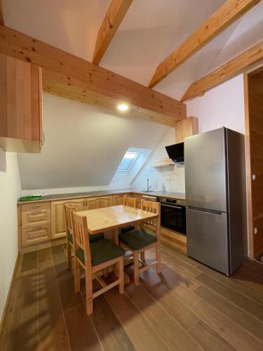 een keuken met een houten tafel en een koelkast bij Apartma LD Puščava in Lovrenc na Pohorju