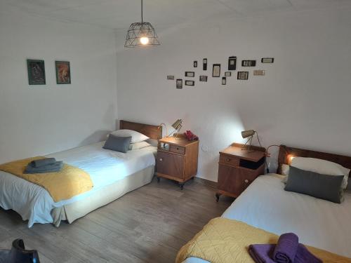 a bedroom with two beds and a dresser and a night stand at Casa Champasak in Órgiva