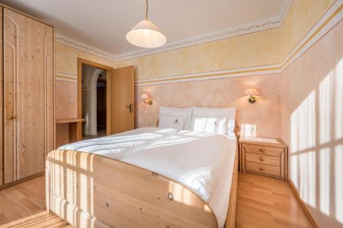 a bedroom with a large white bed in a room at Haus zur Vogelweide App 4 in Dobbiaco