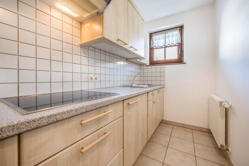 a kitchen with wooden cabinets and a sink and a window at Haus zur Vogelweide App 4 in Dobbiaco