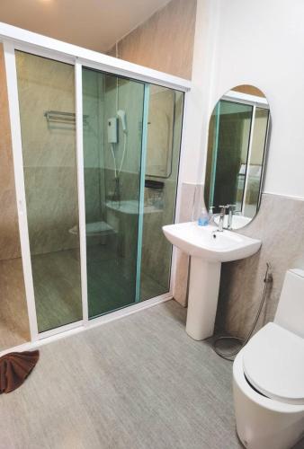 a bathroom with a shower and a toilet and a sink at Varni Homestay in Phatthalung