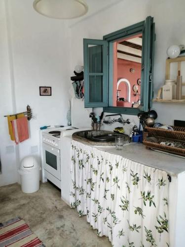 a kitchen with a sink and a mirror on a counter at CASA DEI MELOGRANI at Vourlidia Leros in Vromolithos