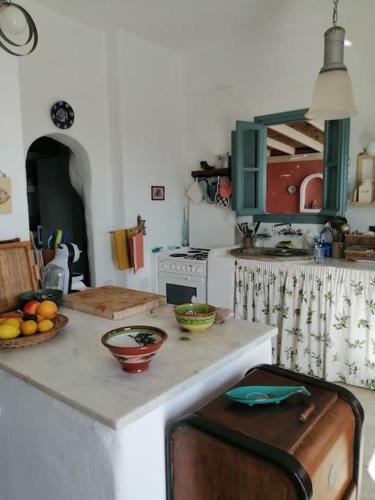 a kitchen with a counter with bowls of fruit on it at CASA DEI MELOGRANI at Vourlidia Leros in Vromolithos