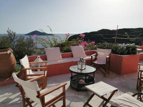 a patio with a couch and chairs and a table at CASA DEI MELOGRANI at Vourlidia Leros in Vromolithos
