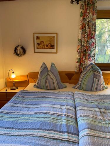 Schlafzimmer mit einem Bett mit blauer Bettwäsche und einem Fenster in der Unterkunft Haus Wittig in Sankt Ulrich am Pillersee