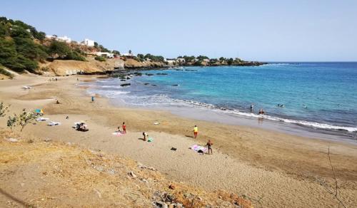 a group of people on a beach near the ocean at Bright Apartment Close to the Beach & City Center in Praia