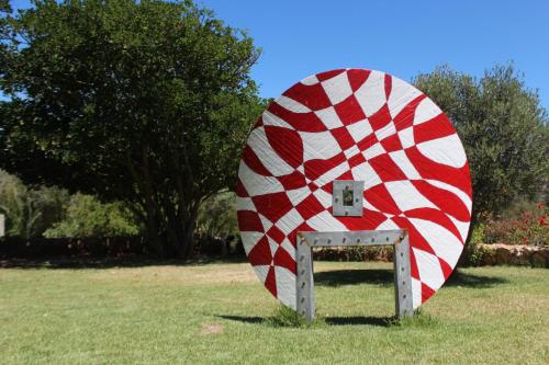 a large red and white object sitting in the grass at Kohinor maison d'hôtes 