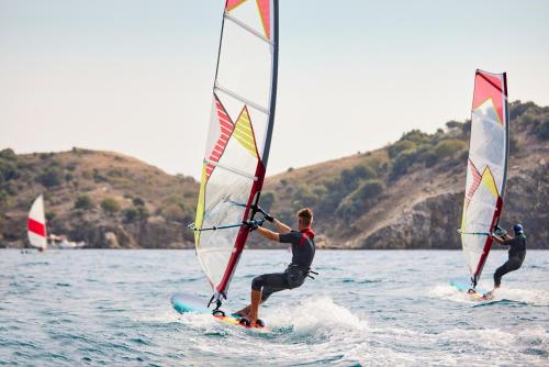 three people are windsurfing on the water with sailboards at TUI MAGIC LIFE Sarigerme in Sarigerme