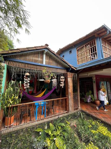 a house with a porch with a hammock on it at Yolo Hostel Medellin in Medellín