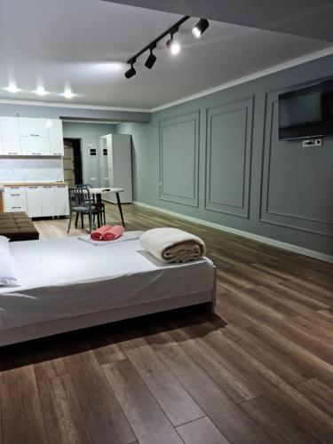 a bedroom with a bed and a kitchen with a table at Апартаменты в центре, в новом доме in Almaty