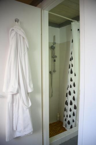 y baño con ducha y albornoz blanco. en Tel Hai City Studio Center Apartment By Nimizz, en Tel Aviv