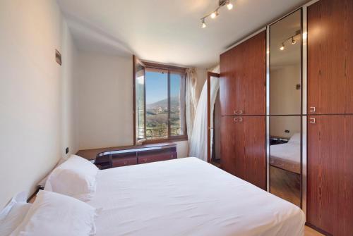 una camera da letto con un grande letto bianco e una finestra di Appartamento Pasqua - Arenzanohost a Cogoleto