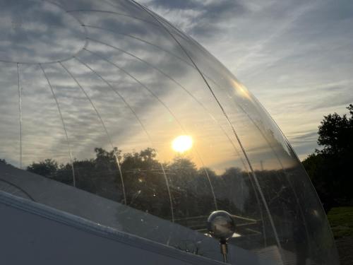 a glass dome with the sunset in the background at Bubble Jade in Val Couesnon