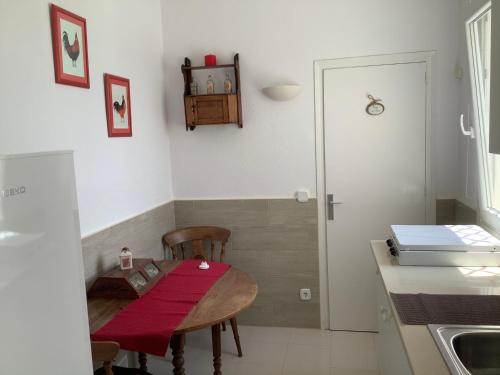 eine kleine Küche mit einem Tisch mit einem roten Tuch drauf in der Unterkunft La Casita in Pau