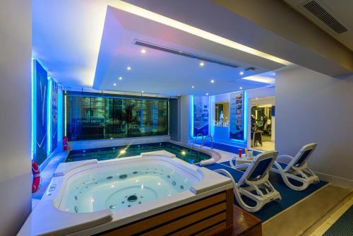 a large jacuzzi tub in a room with chairs at Blue Diamond Hotel Jeddah in Jeddah