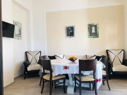 a dining room with a white table and chairs at BIS-A Guesthouse in Makhinjauri