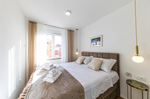 - une chambre avec un grand lit et des serviettes blanches dans l'établissement Apartment Borik, à Zadar