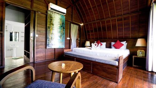 - une chambre avec un lit, une table et une chaise dans l'établissement The Lumbung Wood Villa, à Seminyak