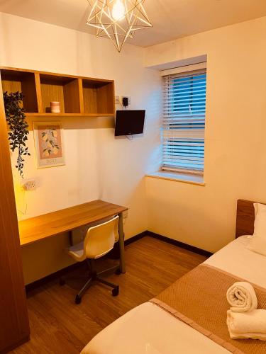 een hotelkamer met een bureau en een bed en een bed en een bureau bij 'Woodbury' at stayBOOM in Lancaster