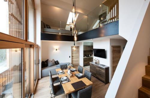 a dining room and living room with a table and chairs at Lerchpeuntgut Alpenfreud Apartments in Tamsweg