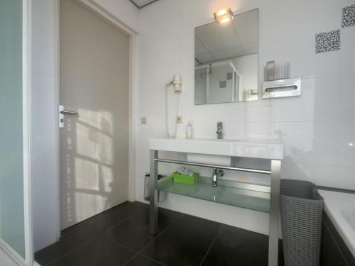 a bathroom with a sink and a mirror at Zeezicht, Kanaalweg 1-408 in Cadzand