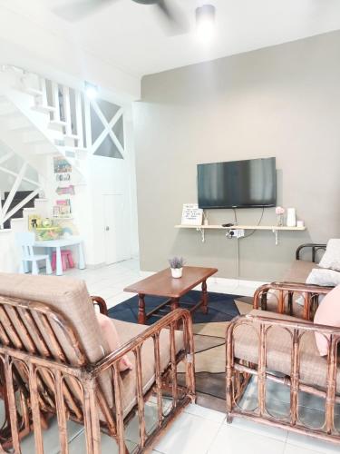 a living room with two chairs and a tv at De'Manda Homestay in Sandakan