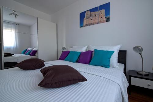 ein Schlafzimmer mit 2 Betten mit Kissen darauf in der Unterkunft Apartments Maris Senj 2 in Vrataruša