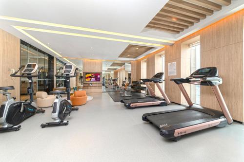a gym with a row of treadms and cardio machines at Nanan Ao Sheng Yi Hao Hotel in Quanzhou