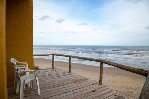 Dos sillas sentadas en un porche con vistas a la playa en Meliodas, en Aguas Dulces