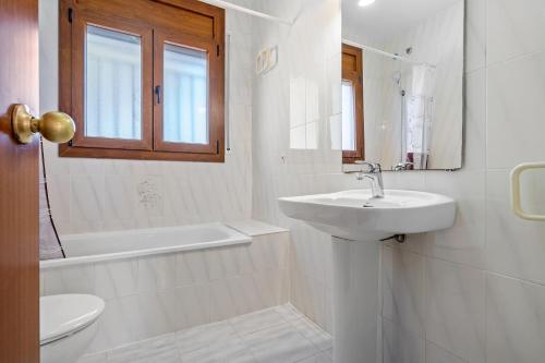 bagno bianco con lavandino e servizi igienici di Coma-ruga a El Vendrell