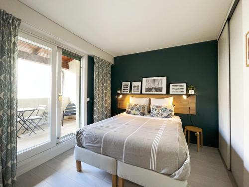 een slaapkamer met een bed met een groene muur bij Limas - Appartement Avignon centre in Avignon