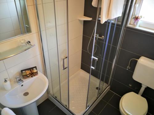 a bathroom with a shower and a sink at Apartments Bilic with garden & swimming pool - 50m from the beach in Pješčana Uvala 
