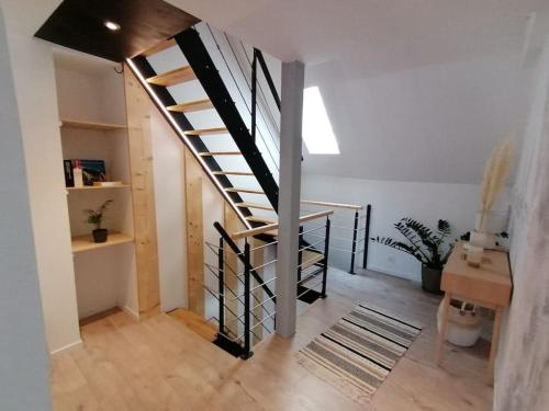 a hallway with a staircase in a house with a desk at Du côté de chez Pam in Beblenheim
