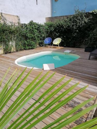 - une petite piscine avec 2 chaises et une chaise bleue dans l'établissement Du côté de chez Pam, à Beblenheim