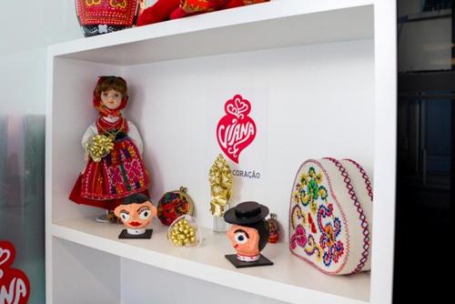 a shelf with dolls in a toy store at Hotel Laranjeira in Viana do Castelo