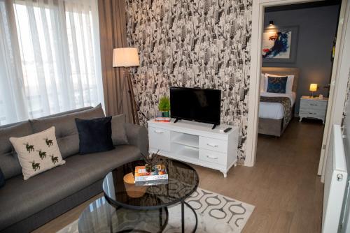 een woonkamer met een bank en een tv bij 12 rooms hotel in Köseilyas