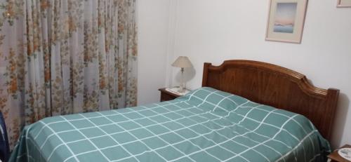 1 dormitorio con 1 cama con edredón azul en Playa Grande hermoso departammento en Mar del Plata