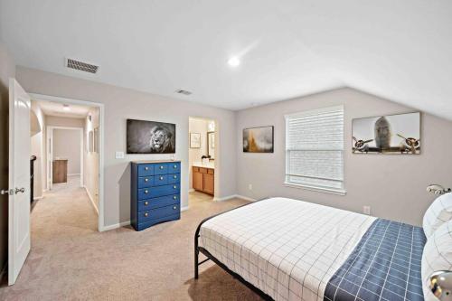 a bedroom with a bed and a blue dresser at Houston House~Sleeps 16~Arcade Style Game Room in Deer Park