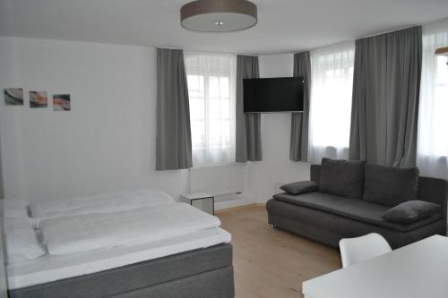 a living room with a bed and a couch at Platia - rooms in Günzburg
