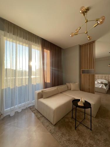 uma sala de estar com um sofá e uma mesa em Square INN Modern Studio City Center em Tirana