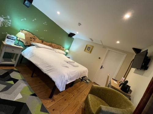 a bedroom with a bed with a green wall at Old Manor House in Axbridge