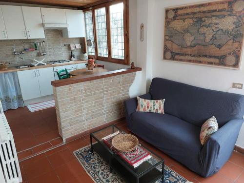 sala de estar con sofá azul y cocina en Villa Tutti i colori del Chianti, en Linari