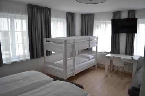 a bedroom with two bunk beds and a desk at Platia - rooms in Günzburg