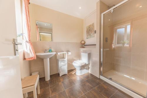 a bathroom with a toilet and a sink and a shower at Lavender Cottage Coniston in Coniston