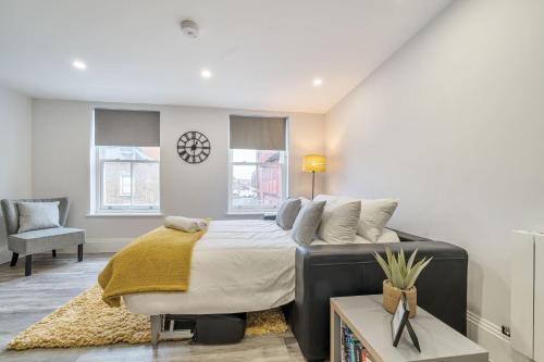 Un dormitorio con una cama y una silla y ventanas. en Boutique Living by Lawsons, en Windsor
