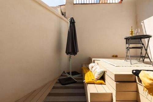 Zimmer mit Holzböden und einem Sonnenschirm in der Unterkunft cozy loft patio+pool +wifi in Valencia