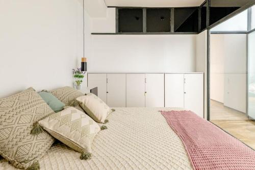 a bedroom with a large bed with pillows on it at cozy loft patio+pool +wifi in Valencia