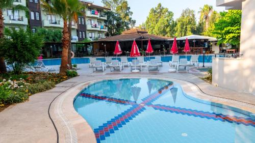 a swimming pool at a hotel with tables and chairs at LEMAS SUITE HOTEL in Side