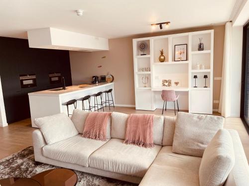 a living room with a couch and a kitchen at Luxe appartement Cadzand-Bad in Cadzand